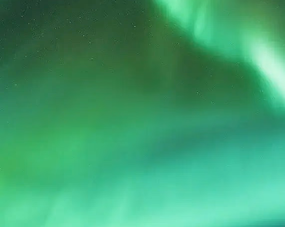 Seilbåt på mørkt hav under grønt nordlys og stjernehimmel
